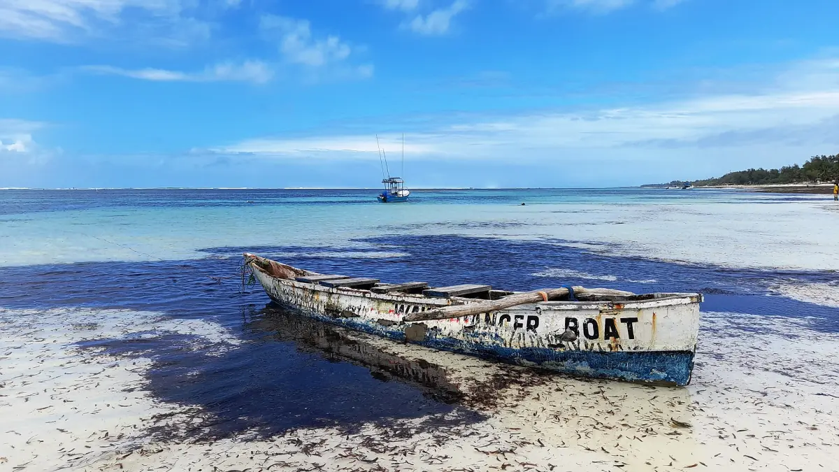 A wooden boat on the sand at low tide in Diani